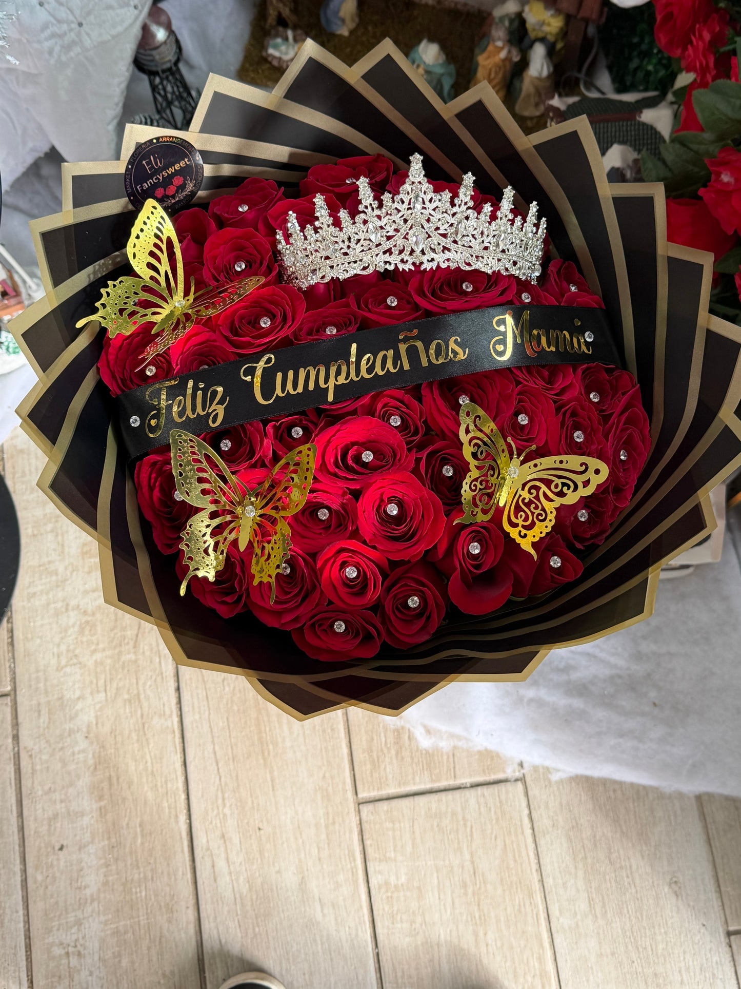 Ramo de 50 rosa rojas naturales con papel negro con dorado en la orilla , una corona grande , 3 mariposas doradas , pequeños alfileres de diamante en cada rosa , una frase personalizada en medio