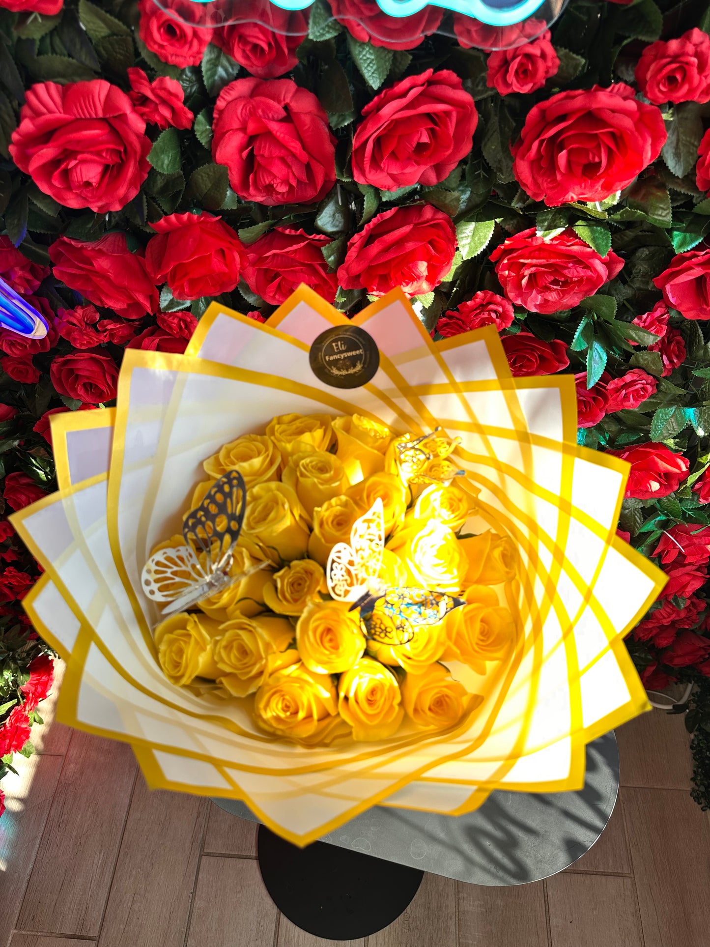 Ramo de 36 rosas amarillas , con papel blanco con dorado en la orilla , con 3 mariposas plateadas