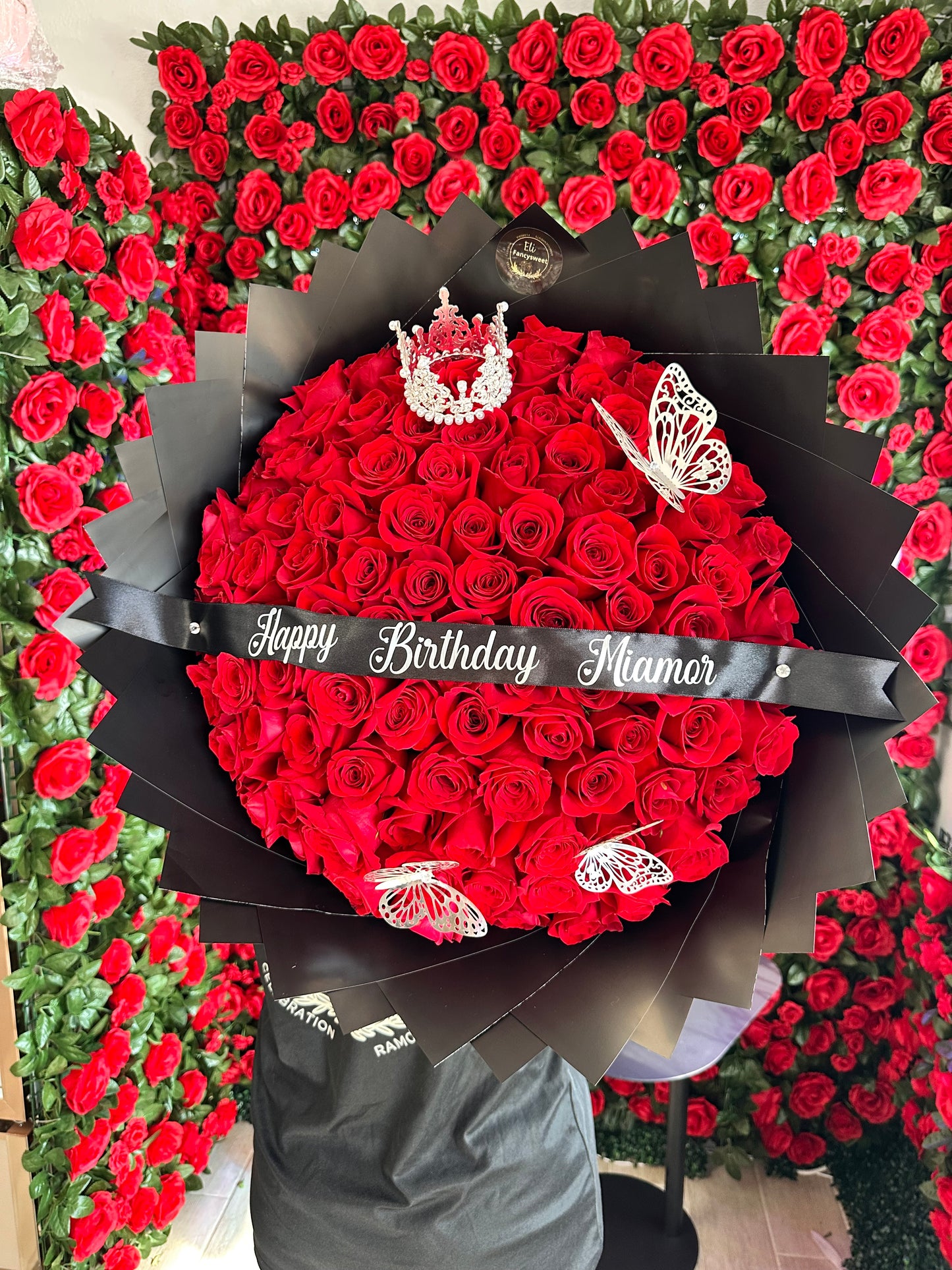 100 rosas rojas con papel negro alrededor con liston personalizado