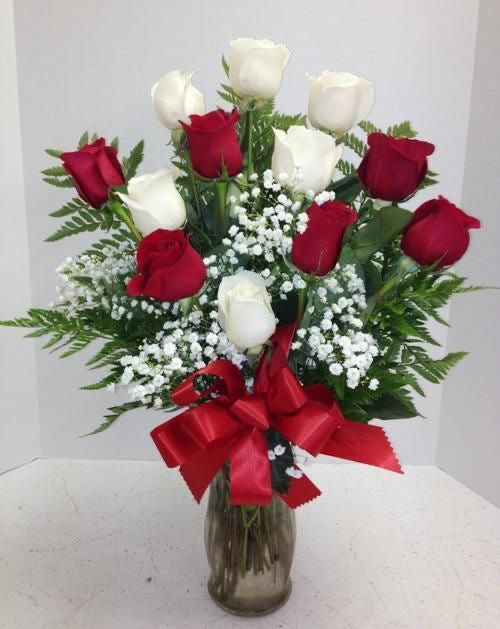 Arreglo floral en florero de cristal con 12 rosas (6rosas blancas y 6 rosas rojas) con baby breath y hojas verdes