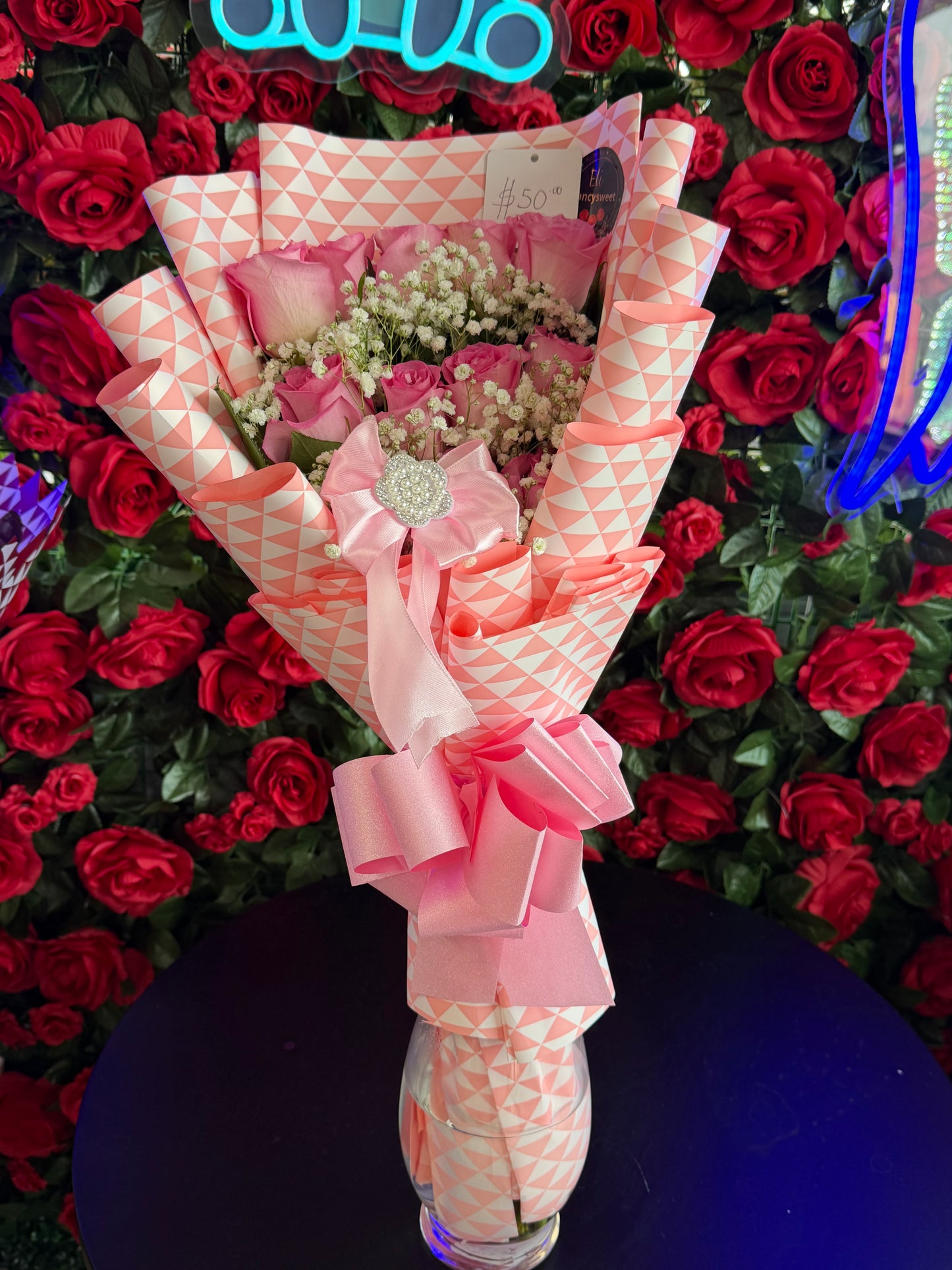 Ramo de 12 Rosas rosado (flat sytle) con baby breath alrededor con papel rosado alrededor, moño rosado de decoración