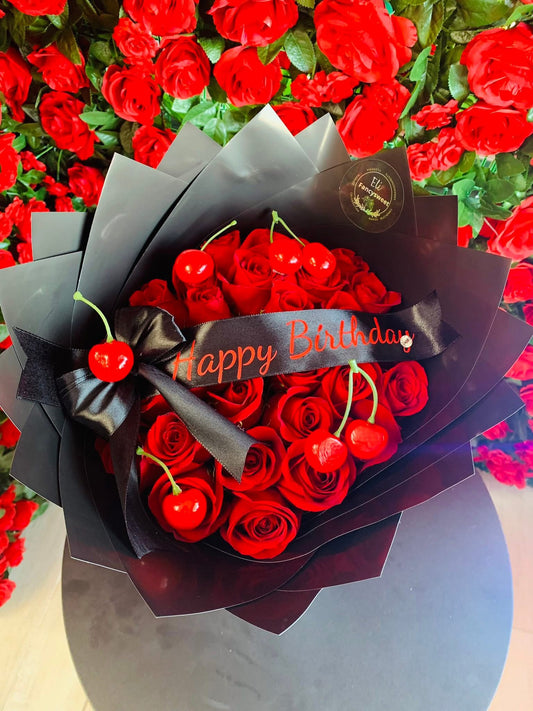 Ramo de 24 rosas rojas con un listón personalizado , papel negro, y cerezas falsas
