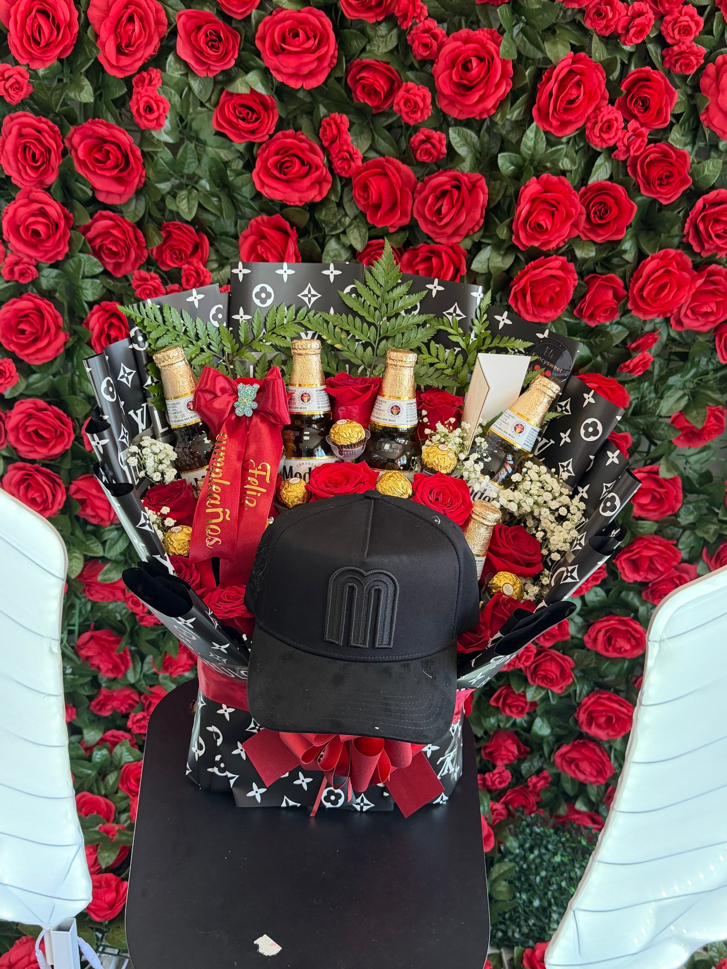 Arreglo floral con 12 rosas rojas naturales , 8 chocolates Ferrero , 6 cervezas en botella modelo , baby breath, una frase personalizada (feliz cumpleaños ) una gorra color negro ,