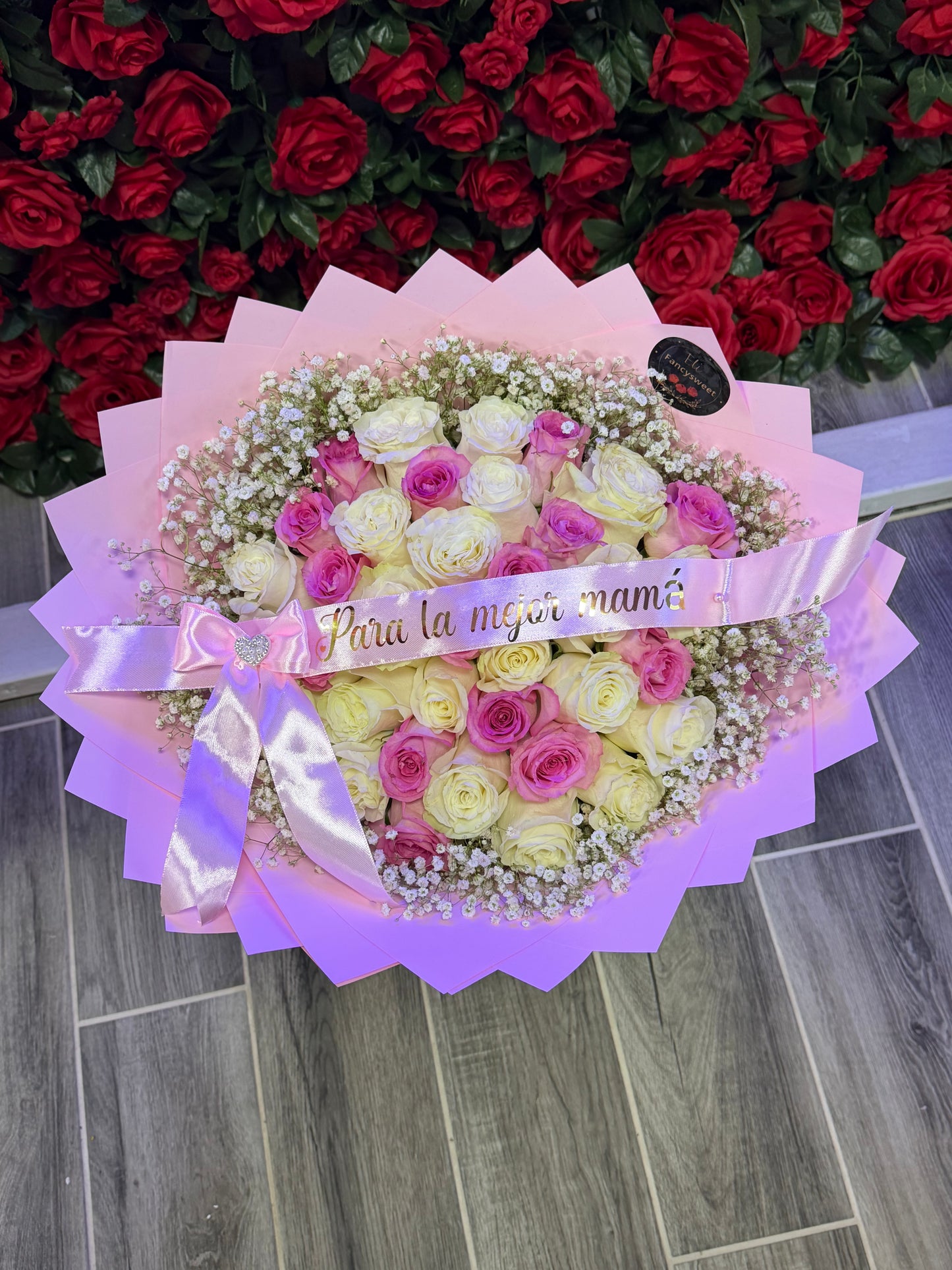 Ramo de 36 rosas rosadas y blancas,con papel rosado ,una capa de baby breath alrededor, una frase personalizada, (para la mejor mamá )