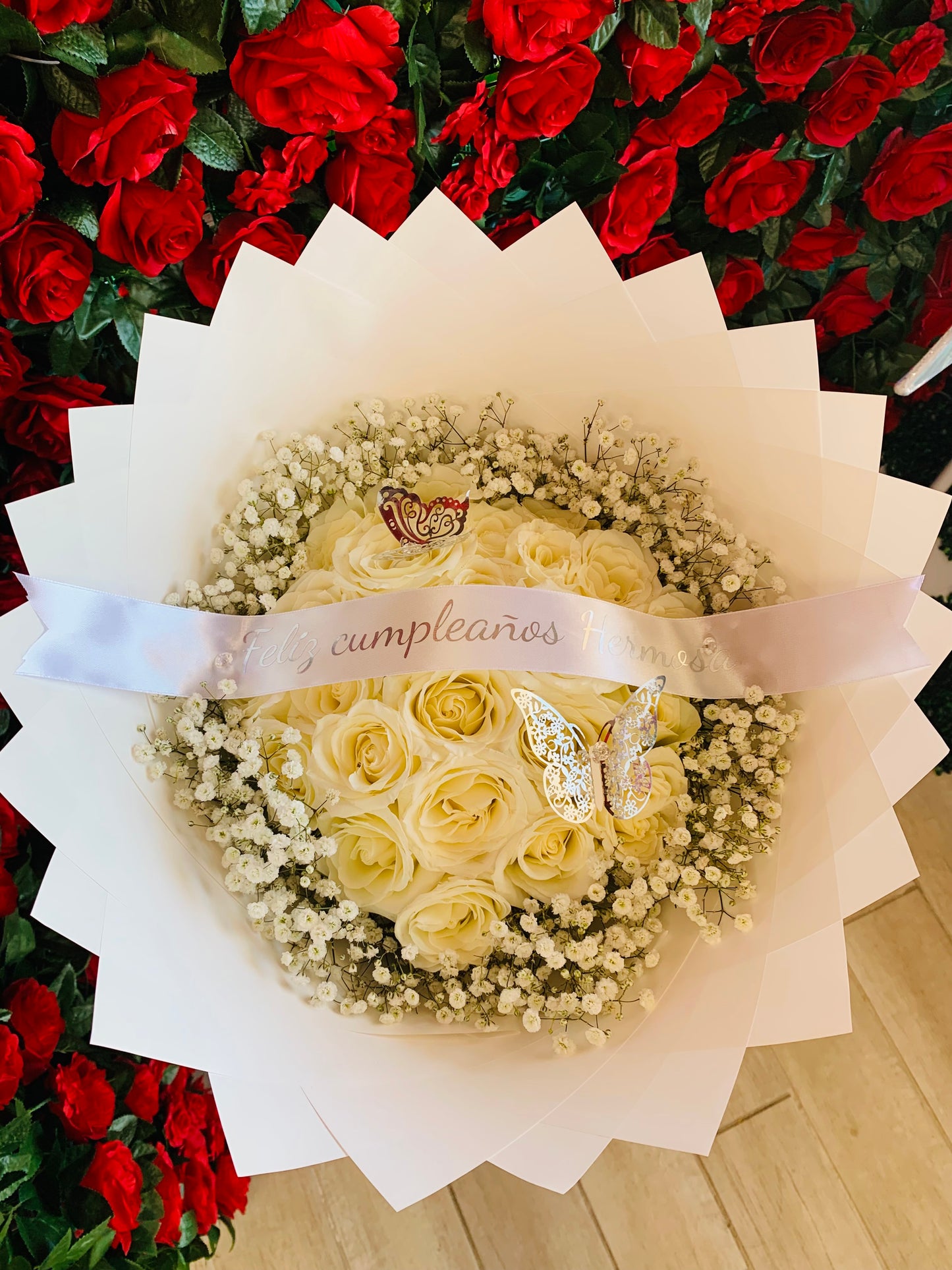 Ramo de 36 rosas blancas con babybreath alrededor , papel blanco,una frase personalizada (Feliz Cumpleaños Hermosa) y dos mariposas plateadas