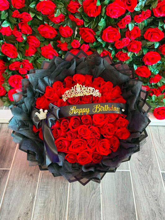 Ramo de 50 rosas rosas ,con papel negro alrededor y una capa de papel crepé , una frase personalizada (happy birthday) y una corona grande color oro