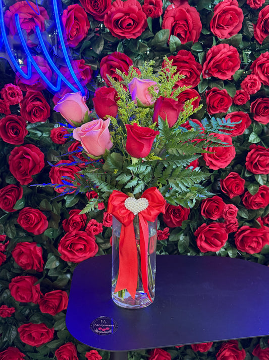 Arreglo en en florero de cristal con 6 rosas con hojitas verdes