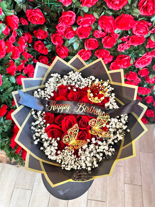 Ramo de 24 rosas rojas con baby breath ( nube) alrededor con papel negro y dorado en la orilla , con una frase personalizada en medio (Happy Birthday)